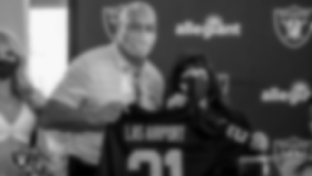 Las Vegas Raiders alumnus Greg Townsend presents McCarran International Airport director of aviation Rosemary A. Vassiliadis with a custom Raiders jersey during the unveiling of a Raiders themed Allegiant Air airplane.