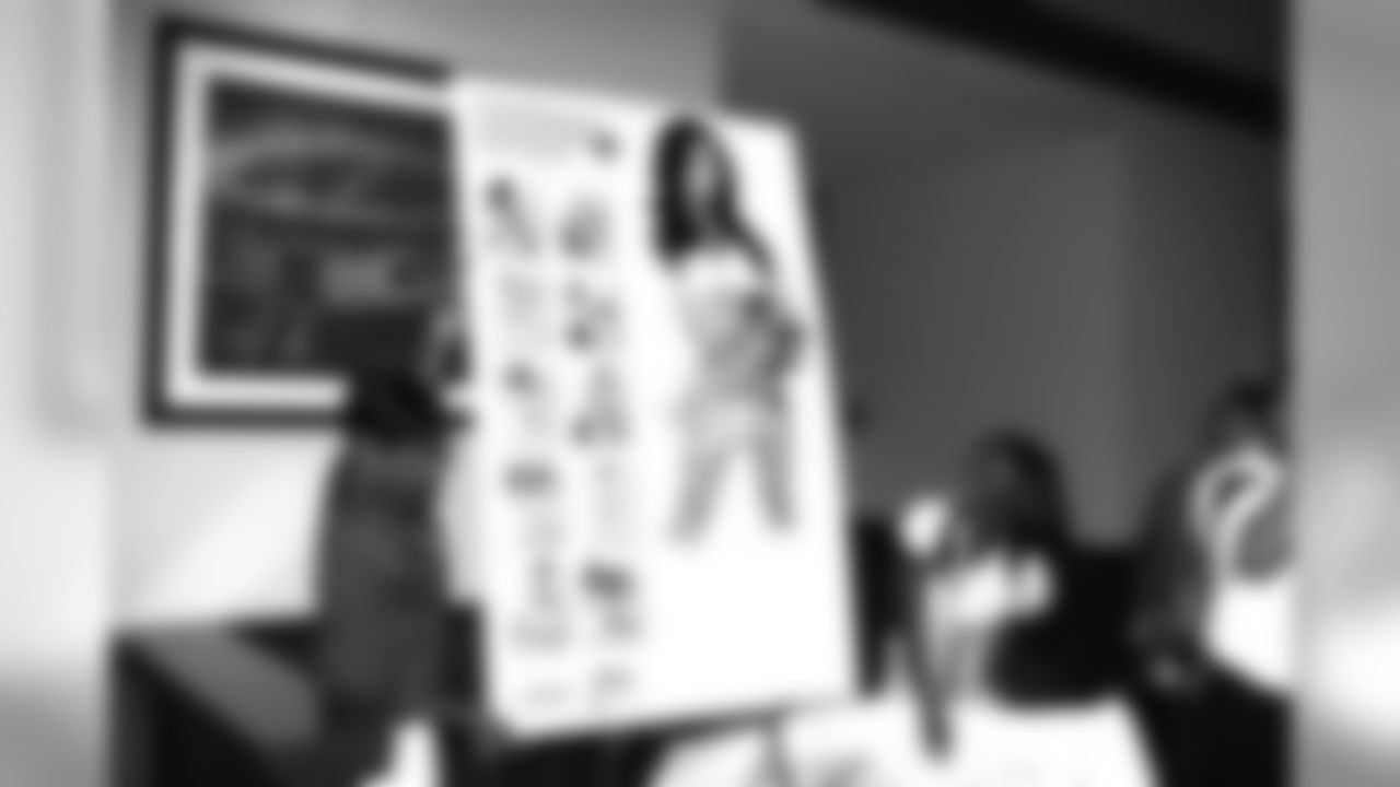 Raiderette Director Jeanette Thompson reveals the back cover of the calendar.