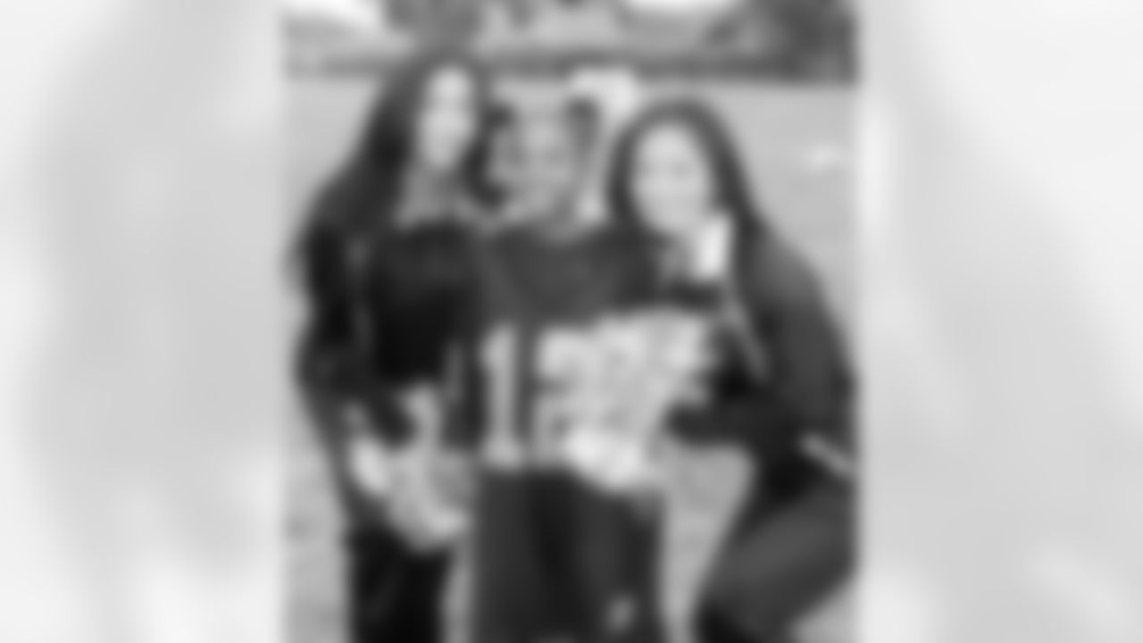 Raiderettes Natalie and Marcy pose for a photo with a young Raiders fan.