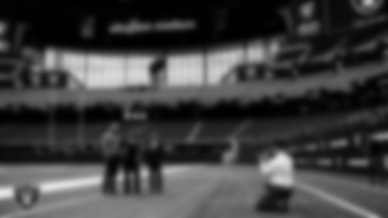 International officers from Air War College take photos on the field during a tour of Allegiant Stadium.