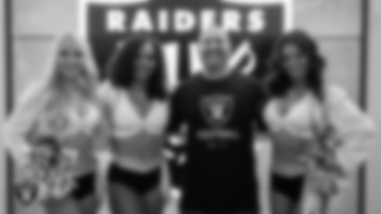 Raiderettes Melody, Makenna P. And Kristina pose for a photo with a first responder during a Thank You, First Responders night.