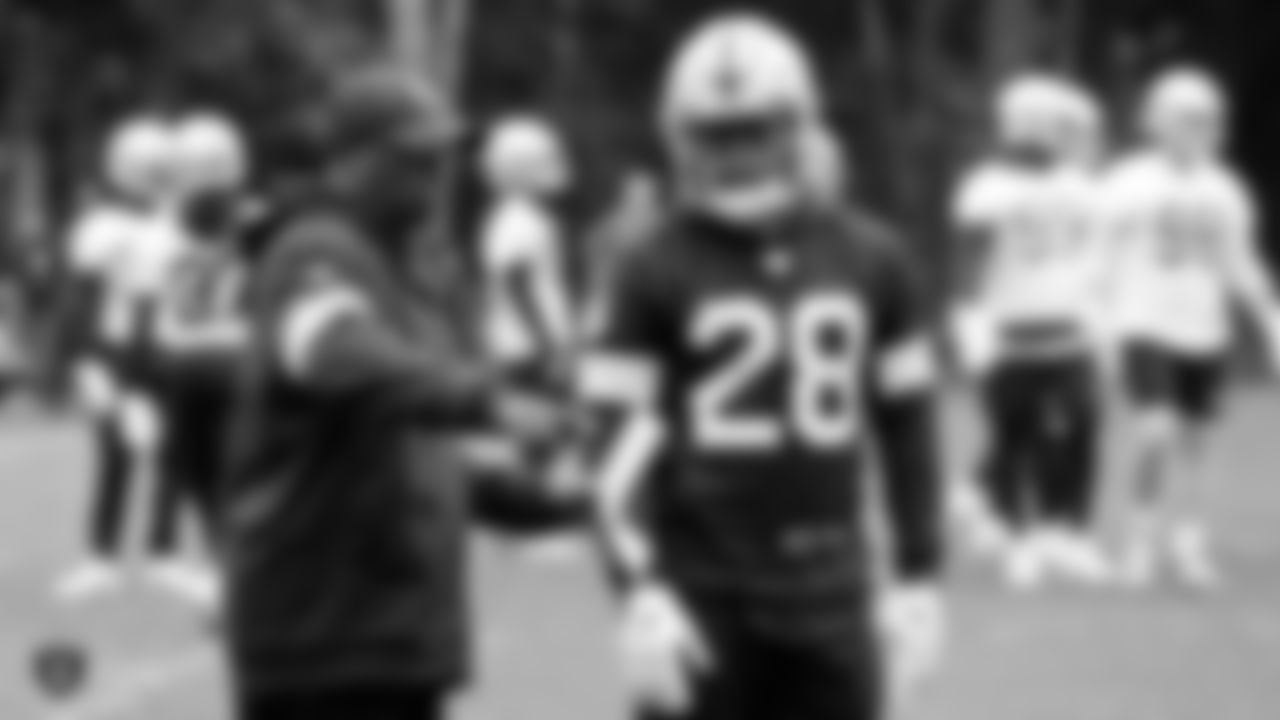 Raiders running backs coach Kirby Wilson and running back Josh Jacobs (28) on the field for practice at The Grove Hotel.