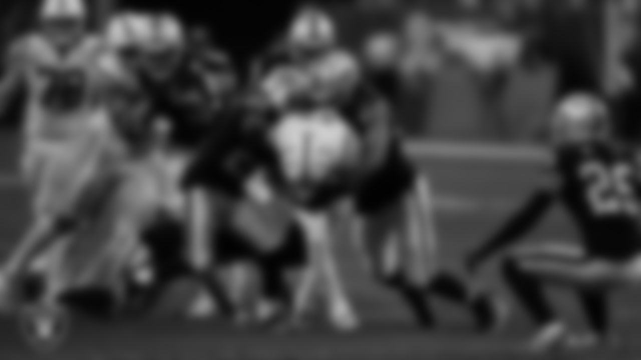Las Vegas Raiders cornerback Amik Robertson (21) and defensive end Tashawn Bower (96) make a tackle during the regular season home game against the Indianapolis Colts at Allegiant Stadium.