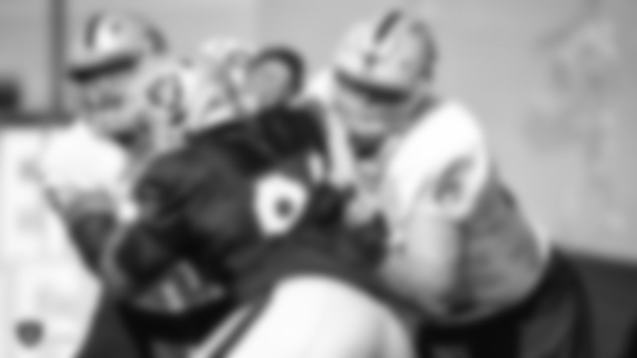 Raiders guard Richie Incognito (64) and tackle Kolton Miller (74) block defensive tackle Corey Liuget (94) during practice.