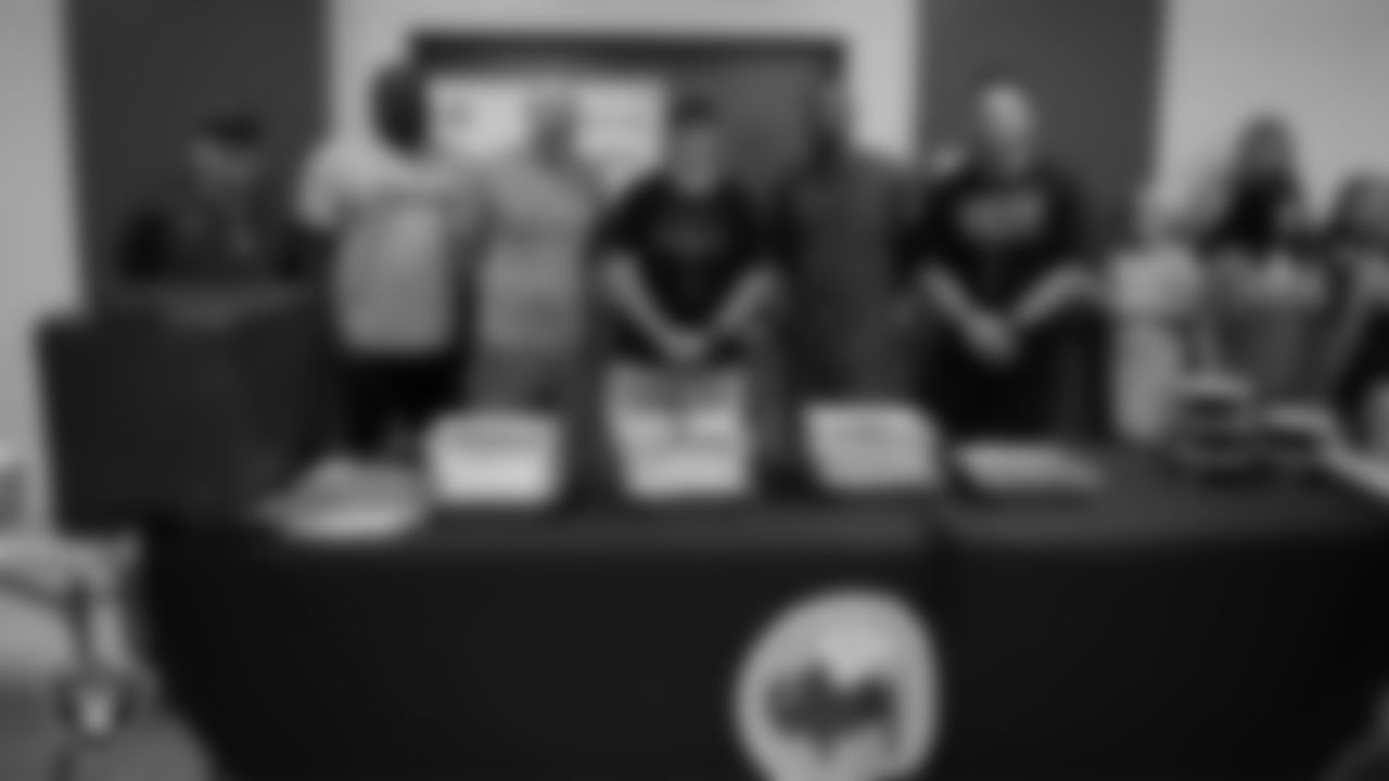 The Green Valley High School footballing coach staff poses for a photo before the players are given Buffalo Wild Wings.
