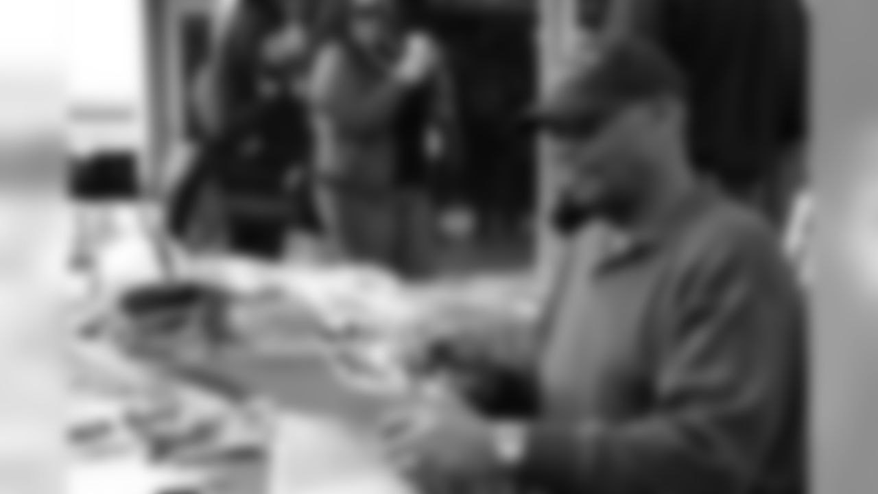 Raiders Legend Ben Davidson signs a photo for a fan.