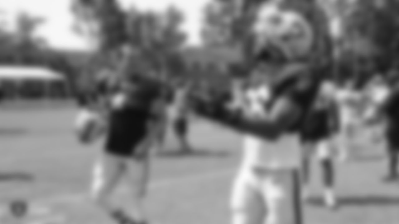 Oakland Raiders quarterback Derek Carr (4) and linebacker Derrick Johnson (56) on the field for practice at 2018 Training Camp at The Oakland Raiders Napa Valley Training Complex, Thursday, August 2, 2018, in Napa, California.