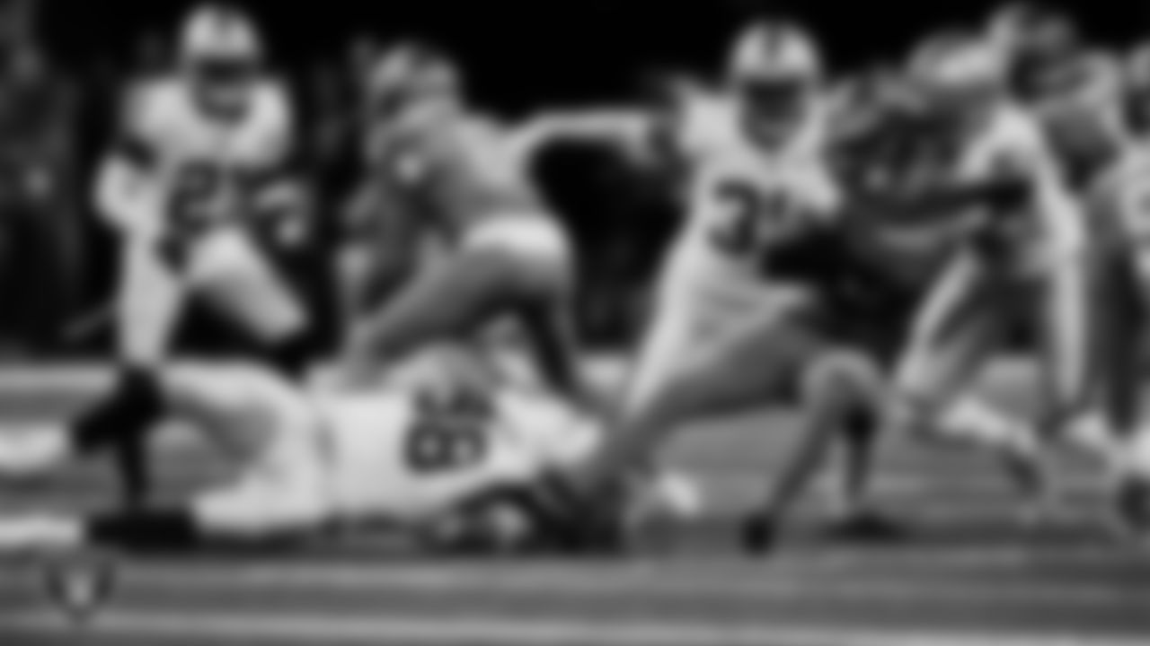 Las Vegas Raiders defensive end Maxx Crosby (98) and defensive end Malcolm Koonce (51) make a tackle during the regular season away game against the Detroit Lions at Ford Field.