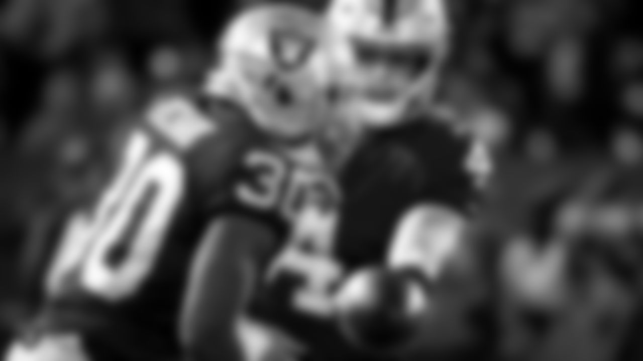Oakland Raiders quarterback Derek Carr (4) hands off to running back Jalen Richard (30) during the Oakland Raiders season game against the Los Angelas Rams at Oakland-Alameda County Coliseum, Monday, September 10, 2018, in Oakland, California. The Oakland Raiders lost 33-13.