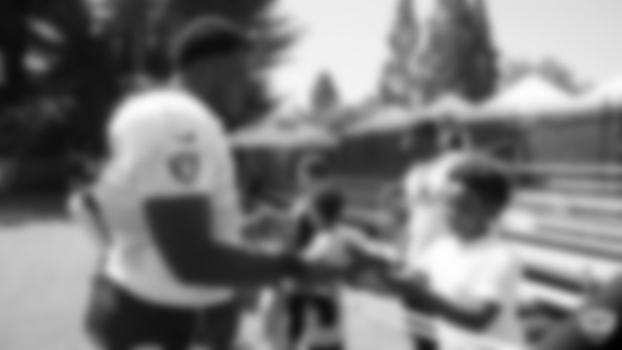 Raiders guard Lester Cotton Sr. (67) signs autographs for fans after practice at 2019 Training Camp.