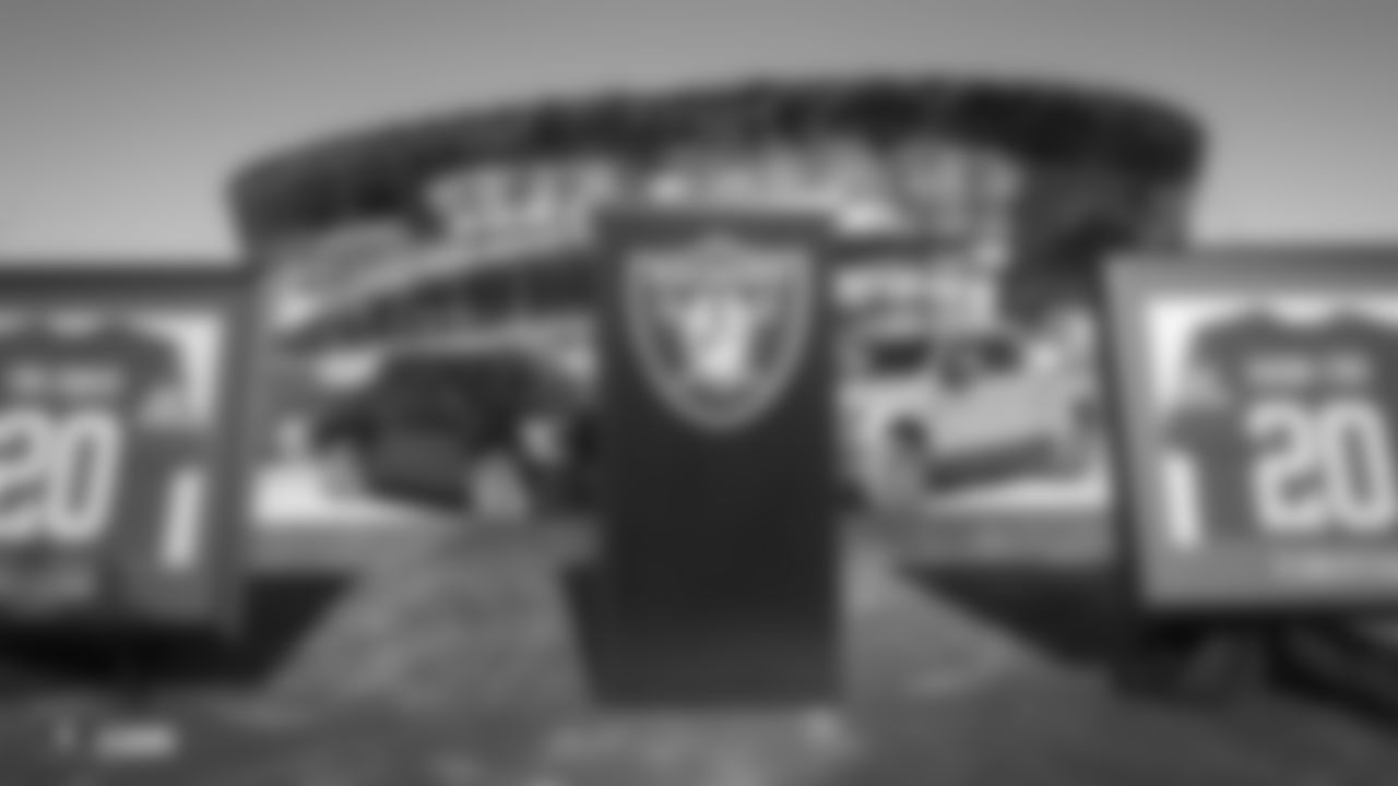 Ford trucks are parked behind a Raiders podium at a private event celebrating Desert Ford Dealers' new partnership with Allegiant Stadium and the Raiders.