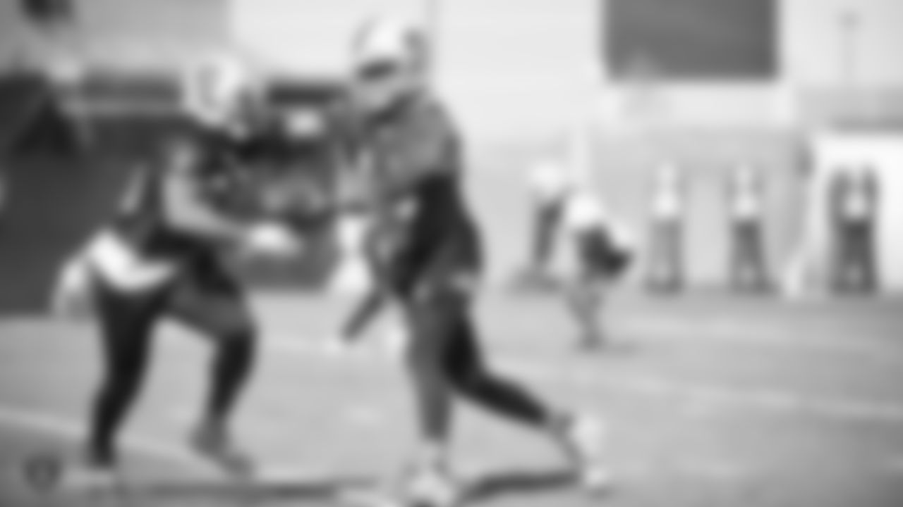 Oakland Raiders quarterback DeShone Kizer (14) hands the ball off to running back DeAndré Washington (33) during practice.