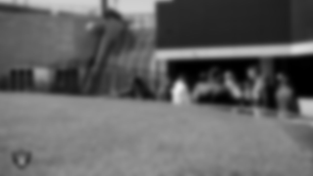 An international officer from Air War College touches the grass during a tour of Allegiant Stadium.
