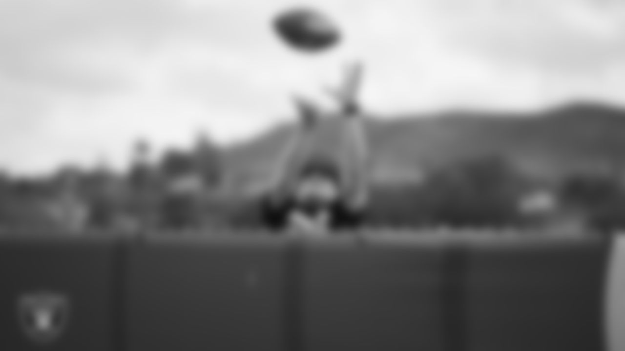 A Las Vegas Raiders fan catches an autographed football during the Raiders' joint practice with the Los Angeles Rams at 2021 Training Camp.