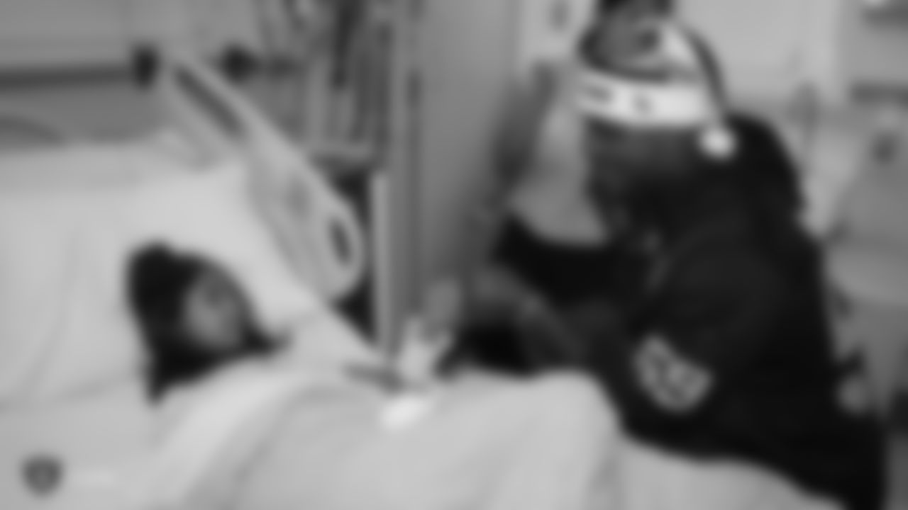 Raiders linebacker Tahir Whitehead (59) fist bumps a young patient during a visit to UCSF Benioff Children's Hospital Oakland.