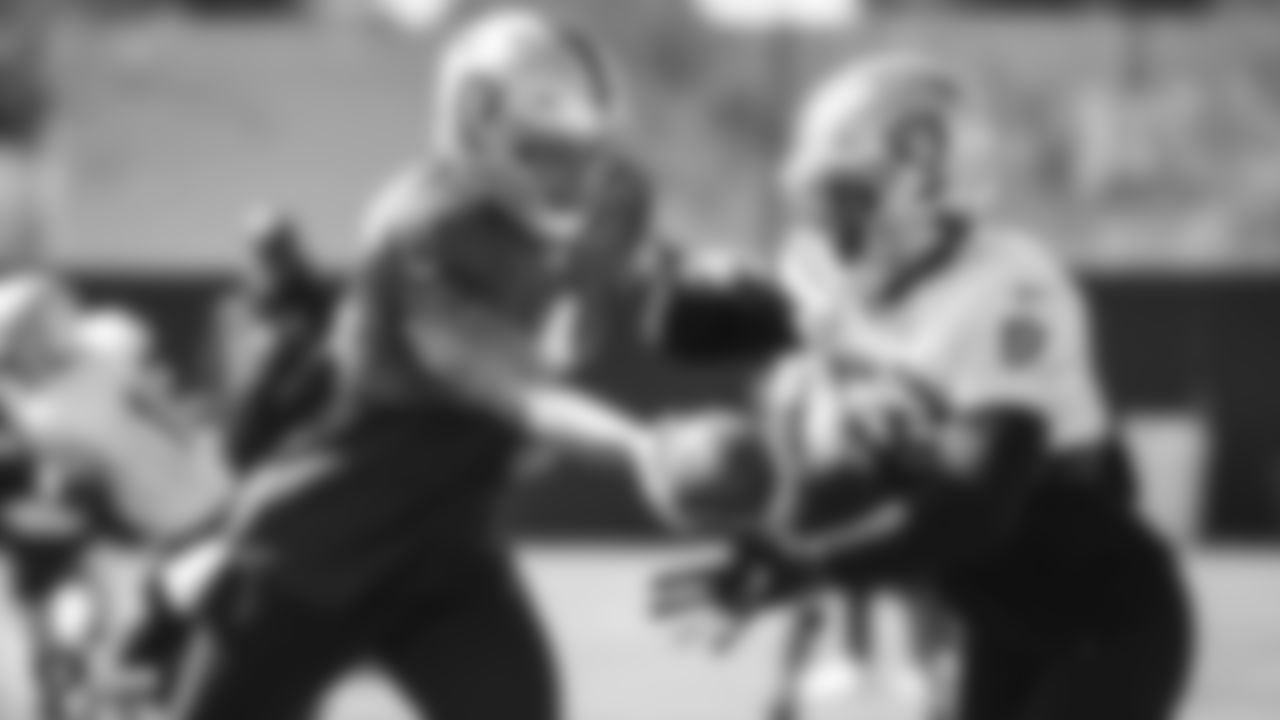 Raiders quarterback Derek Carr (4) hands the ball off to running back Josh Jacobs (28) during practice.