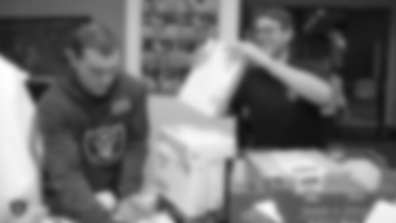 Oakland Raiders linebacker Kyle Wilber (58), tight end Paul Butler (84), tackle Jamar McGloster (64), defensive tackle Clinton McDonald (97), linebacker Shilique Calhoun (91), long snapper Andrew DePaola (48), the Raiderettes, and the Raiders Front Office in Alameda build care packages for victims of the Norther California Fires, Tuesday, November 20, 2018, in Alameda, California.