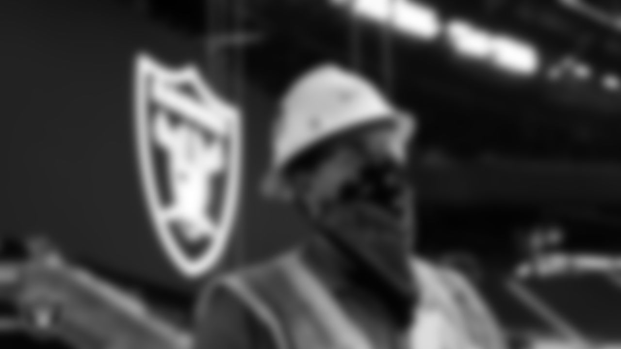 Construction workers wait to watch a special message on the video boards at Allegiant Stadium delivered by Las Vegas Raiders Head Coach Jon Gruden.