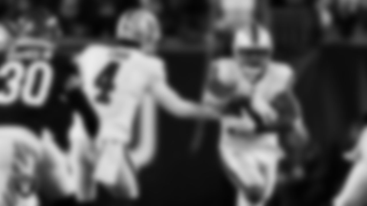 Las Vegas Raiders quarterback Derek Carr (4) hands the ball off to running back Josh Jacobs (28) during the postseason away game against the Cincinnati Bengals.