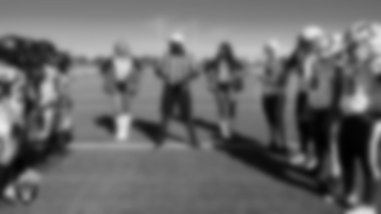 Raiderettes Rachel and Gabby L. stand on the field with team captains from the Apex Predators and the LV Tribe during the coin toss during the American Youth Football & Cheer Regional Championships at Del Sol High School.