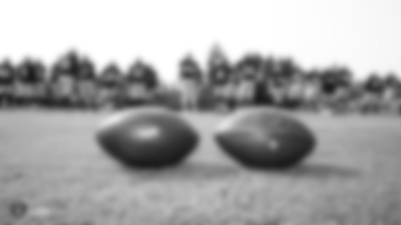 Oakland Raiders footballs with players in the background on the field for practice at 2018 Training Camp at The Oakland Raiders Napa Valley Training Complex, Monday, August 7, 2018, in Napa, California.