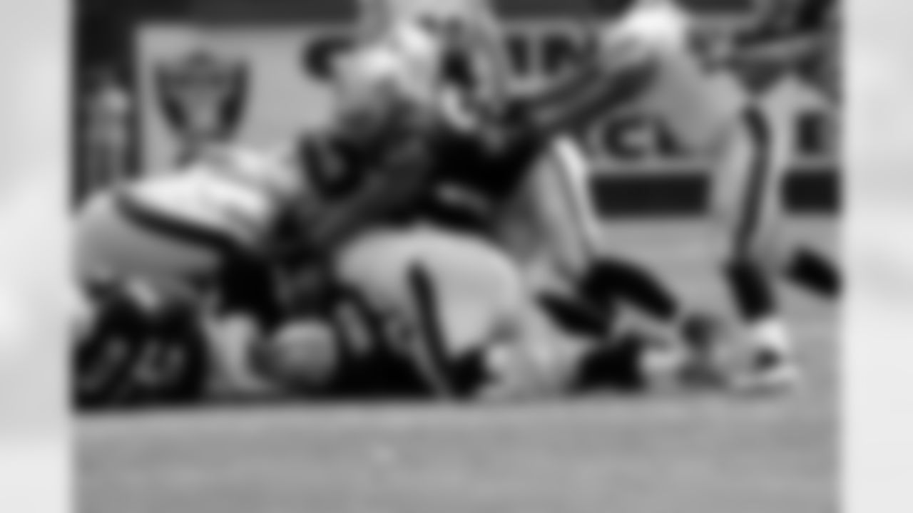The Raiders defense dives on the loose ball.