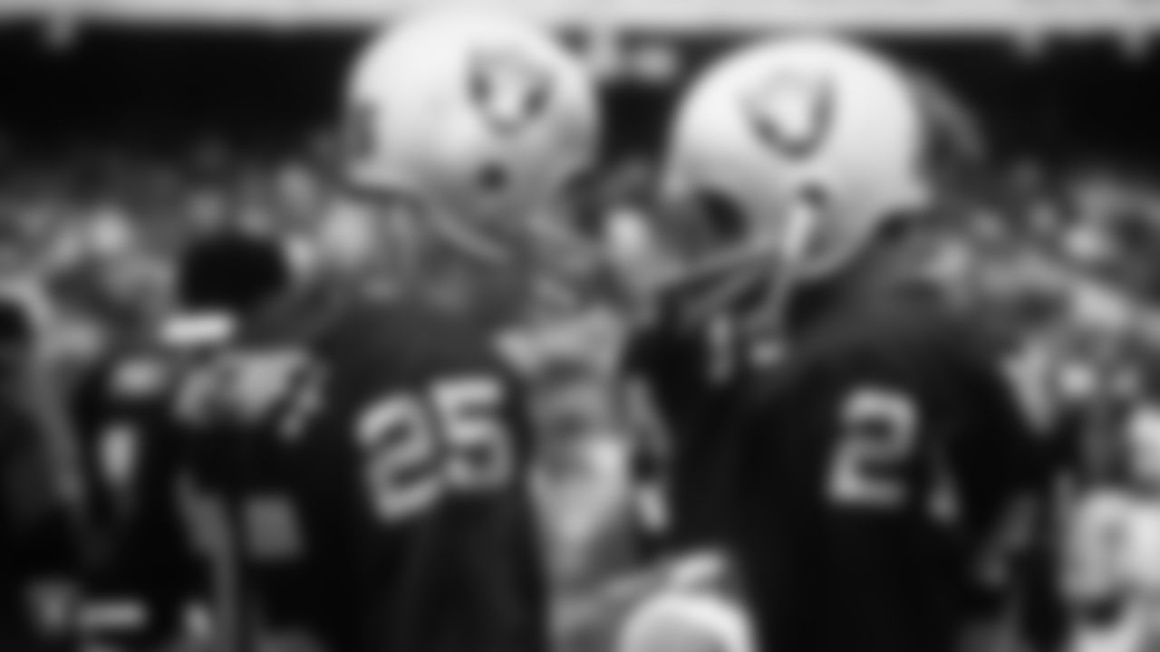 Raiders wide receiver Fred Biletnikoff (25) talks with Raiders wide receiver Cliff Branch (21) on the sidelines.