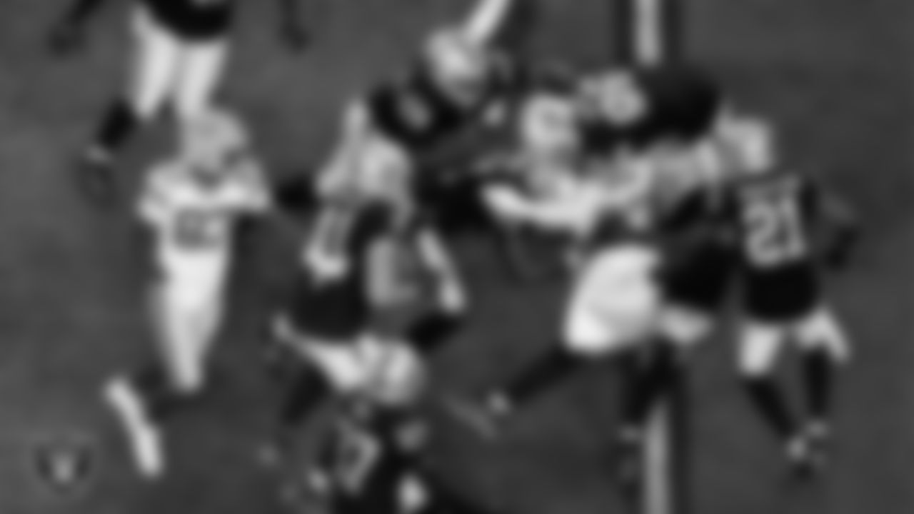 Las Vegas Raiders defensive end Malcolm Koonce (51), defensive end Maxx Crosby (98) and linebacker Divine Deablo (5) make a tackle during the regular season home game against the Green Bay Packers at Allegiant Stadium.