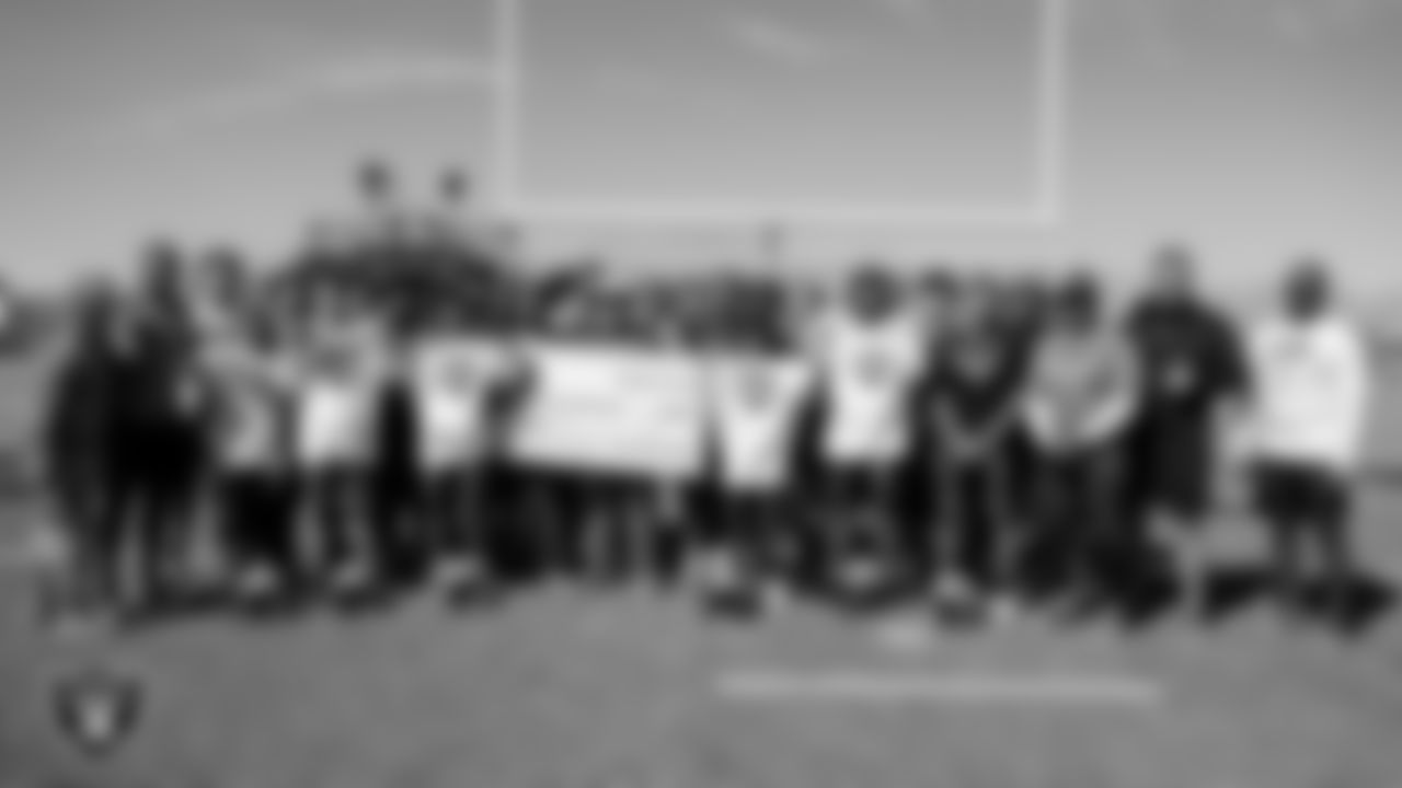 Las Vegas Raiders linebacker Malik Reed (52) and offensive lineman Jordan Meredith (61) pose for a photo with the Cheyanne High School football team before their practice at Cheyanne High School.