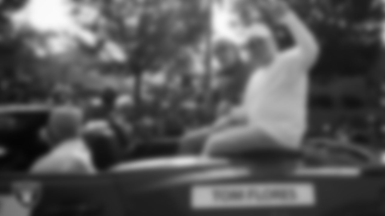 Hall of Famer Tom Flores and Las Vegas Raiders Owner Mark Davis ride in the back of a convertible during the Canton Repository Grand Parade.