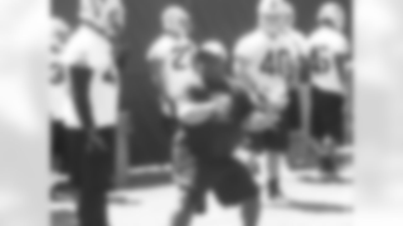 Running backs coach Kelly Skipper demonstrates for players