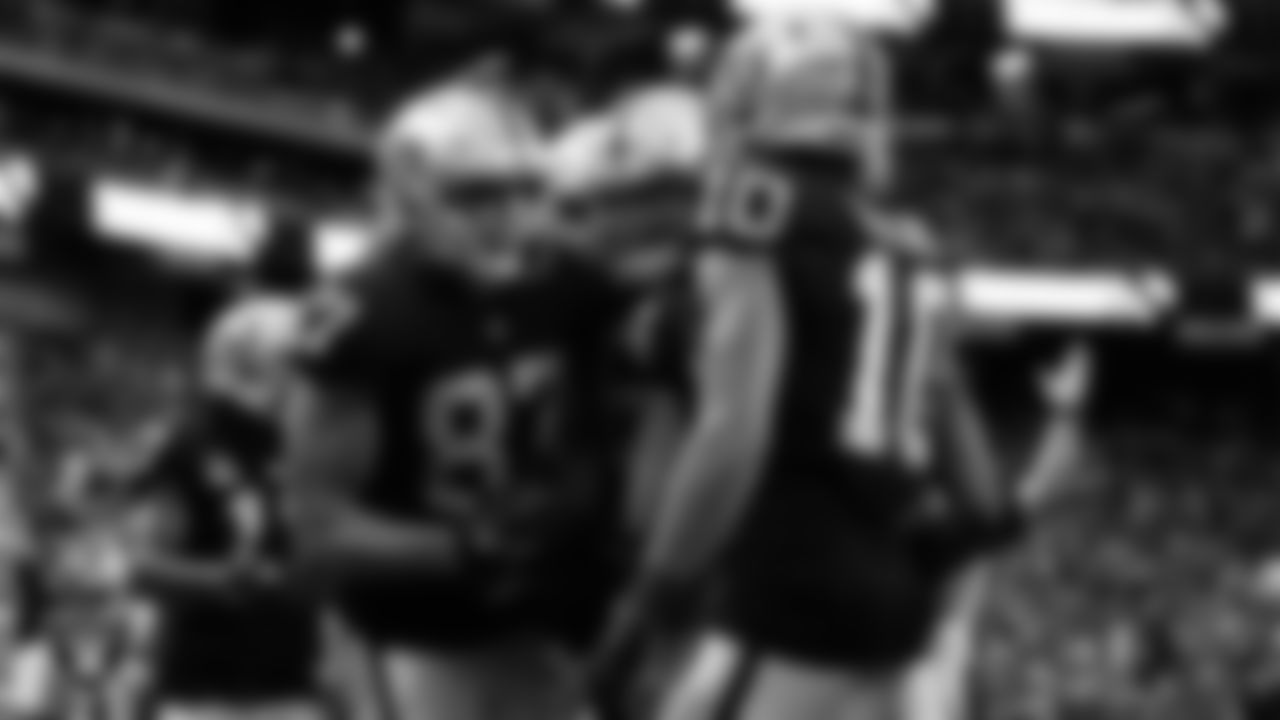 Las Vegas Raiders tight end Foster Moreau (87) is congratulated by center Andre James (68) and wide receiver Mack Hollins (10) after making a 4-yard touchdown catch during the regular season home game against the Indianapolis Colts at Allegiant Stadium.