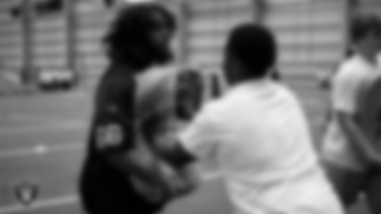 Las Vegas Raiders guard Dylan Parham (66) works with an athlete as they participate in drills during the ELITE Academy at Las Vegas Raiders Headquarters.