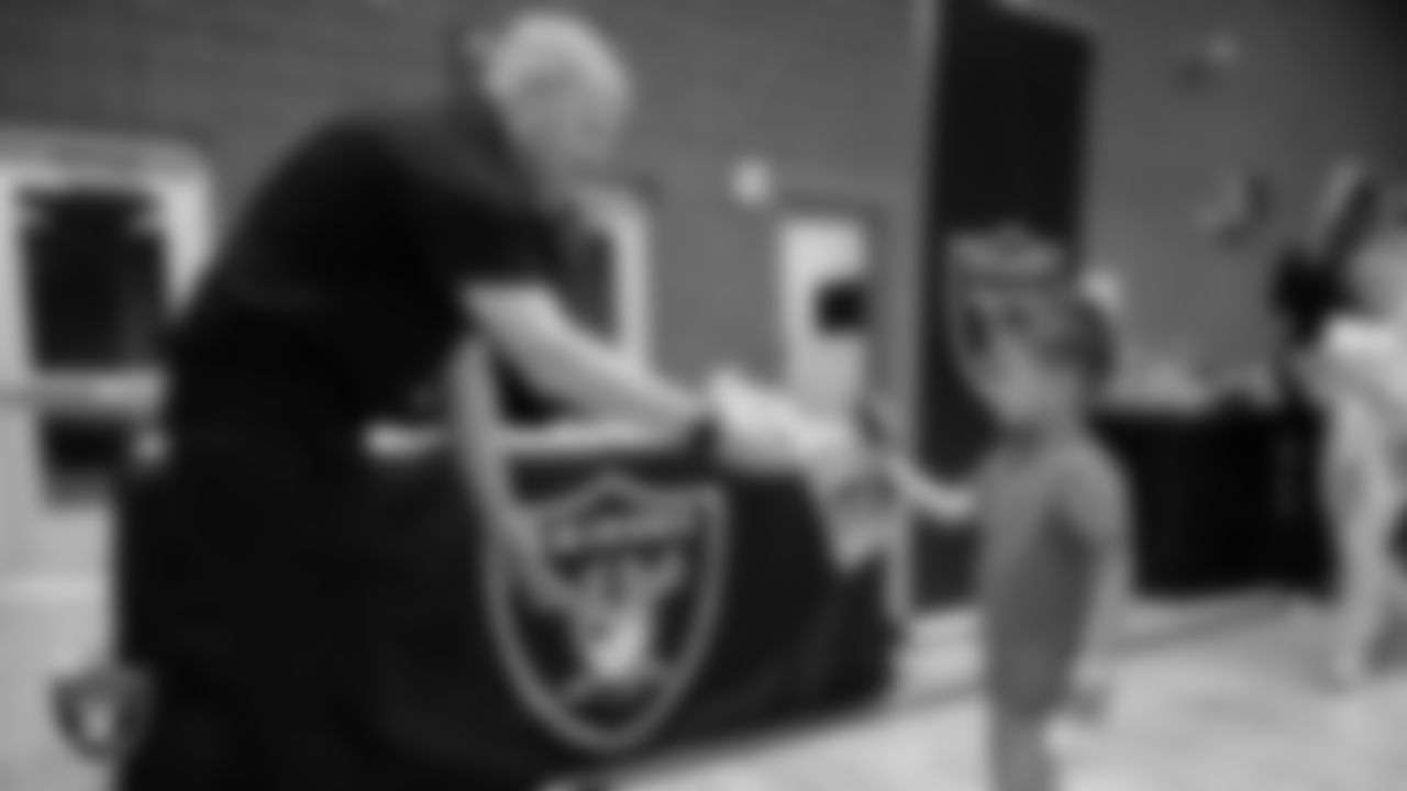 A youth community member receives Las Vegas Raiders gear at the Raiders Stretch & Move station during CCSD's Paralympic Night at J.D. Smith Middle School.
