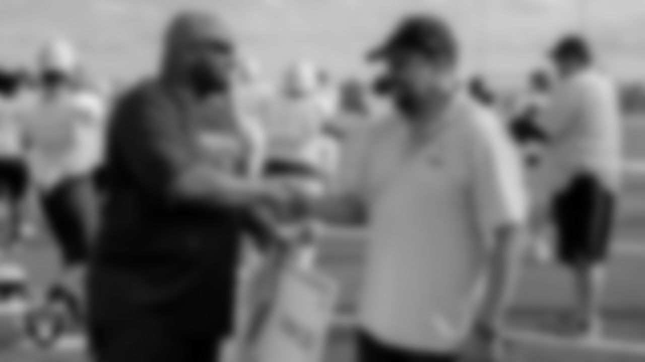 Las Vegas Raiders alumnus Keith Moody talks with Spring Valley High School's football coach, Marcus Teal.