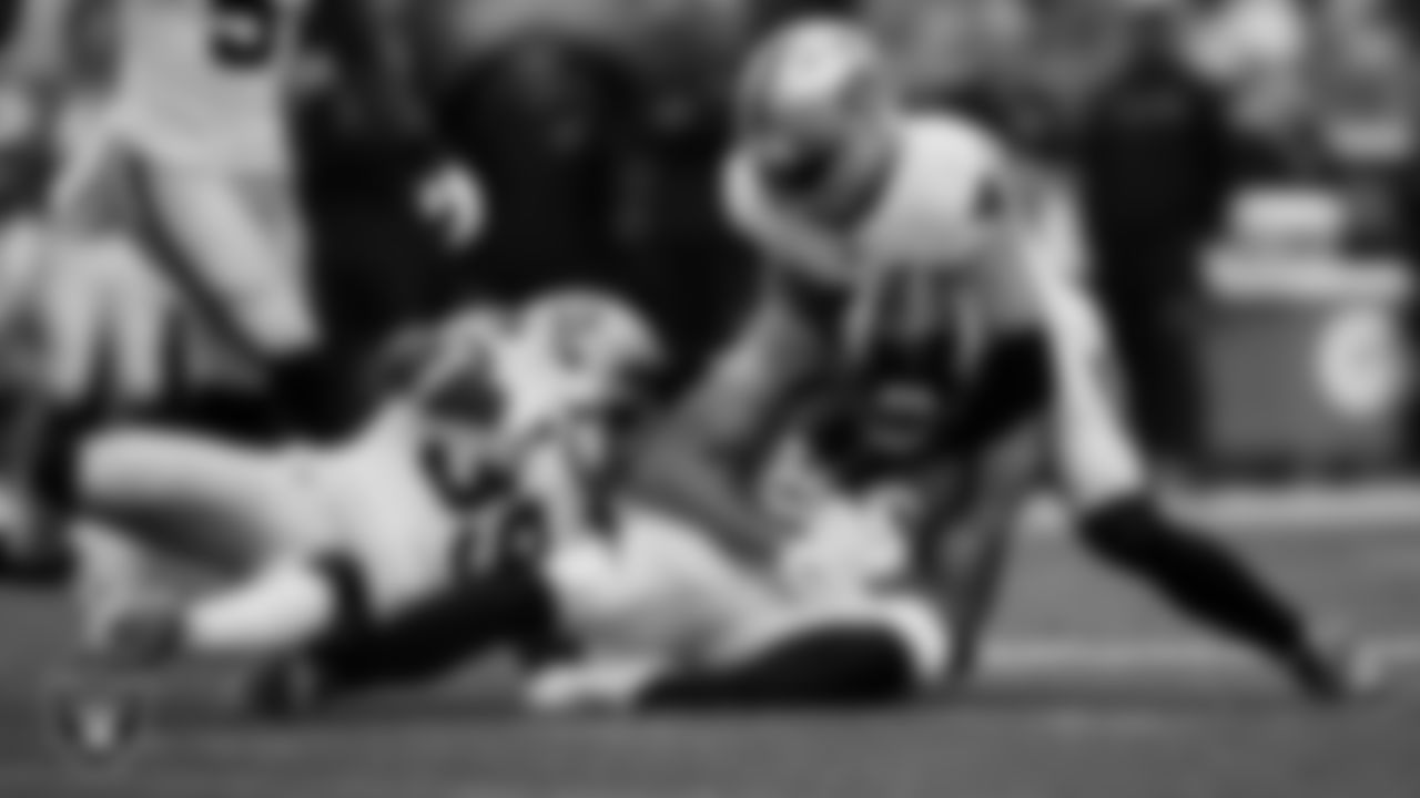 Las Vegas Raiders cornerback Nate Hobbs (39) and linebacker Robert Spillane (41) make a tackle during the regular season away game against the Denver Broncos at Empower Field at Mile High.