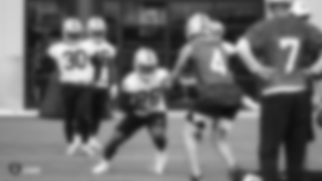 Raiders quarterback Derek Carr (4) hands the ball off to running back Josh Jacobs (28) during practice.