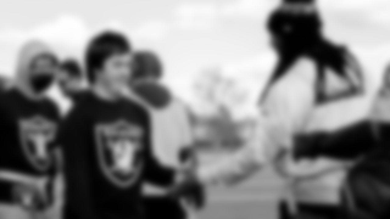 Las Vegas Raiders alumnus Usma Young high fives a Liberty High School student after the Unified flag football game.