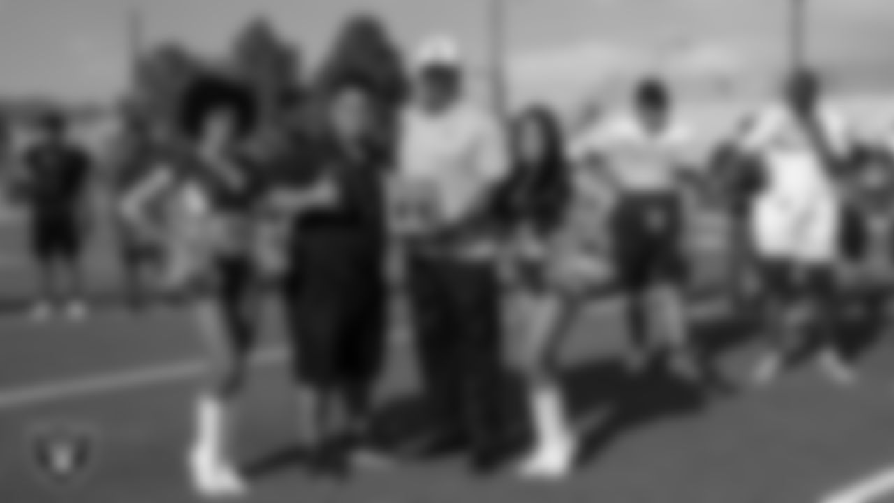 Raiderettes Vicky and Meghan and Las Vegas Raiders alumnus Roy Hart present Mojave High School's football coach Wes Pacheco with the Tom Flores High School Coach of the Week award.