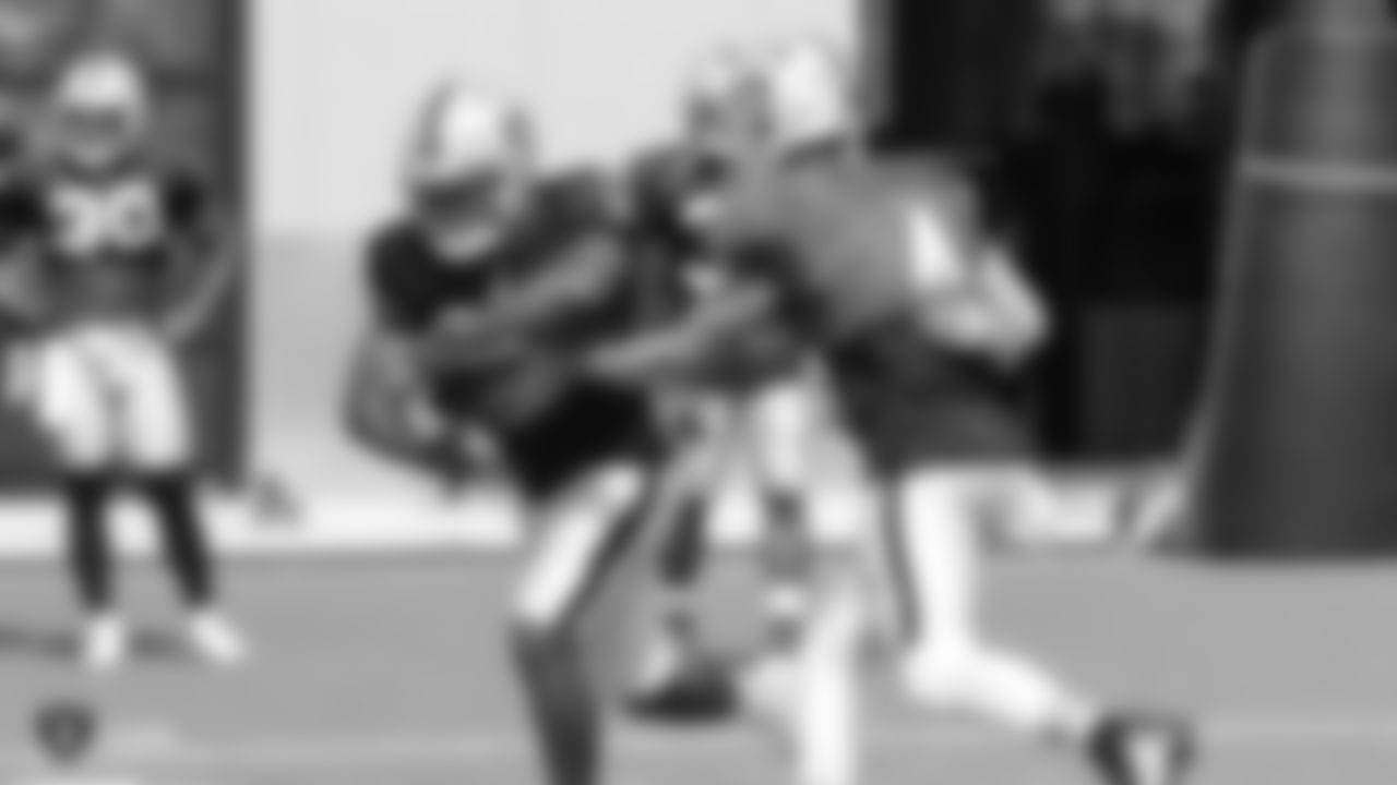 Raiders running back Josh Jacobs (28) and quarterback Derek Carr (4) on the field for practice.