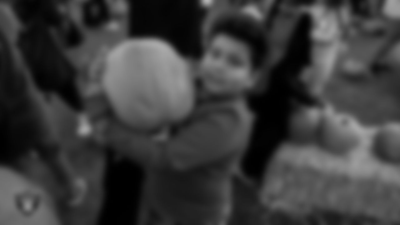 A member of the Boys and Girls Clubs of Southern Nevada grabs a pumpkin out of the pumpkin patch.