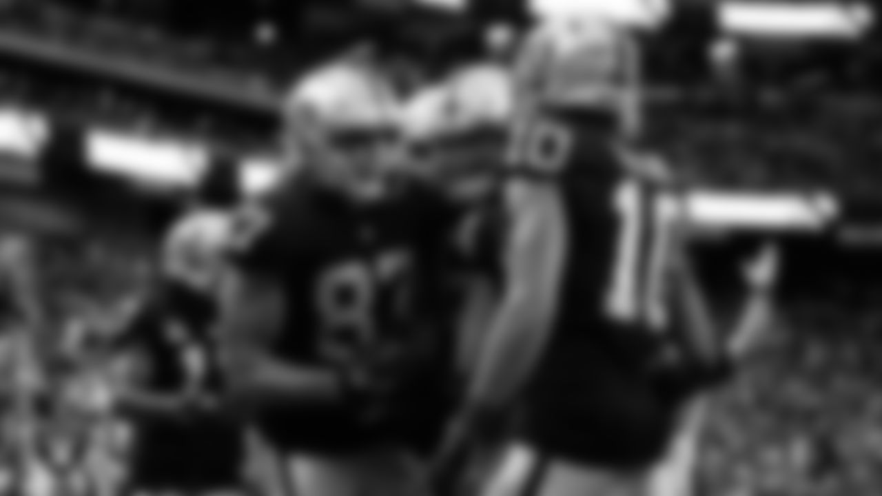 Las Vegas Raiders tight end Foster Moreau (87) is congratulated by center Andre James (68) and wide receiver Mack Hollins (10) after making a 4-yard touchdown catch during the regular season home game against the Indianapolis Colts at Allegiant Stadium.