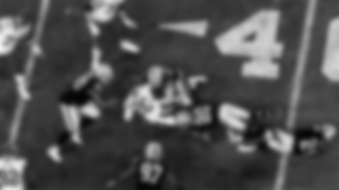 Las Vegas Raiders defensive tackle Johnathan Hankins (90), defensive end Maxx Crosby (98) and cornerback Damon Arnette (20) make a tackle during the regular season home game against the Kansas City Chiefs.
