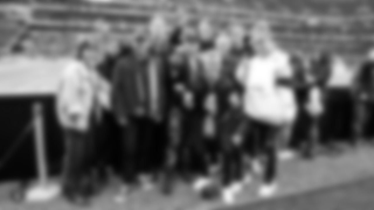 Musical artist Alex DeLeon and model Josephine Skriver, along with friends and family, pose for a photo on the sidelines before the regular season game against the Chicago Bears at Tottenham Hotspur Stadium.