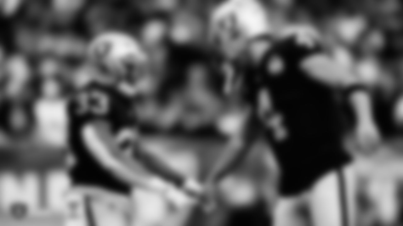 Raiders running back DeAndré Washington (33) and quarterback Derek Carr (4) after a touchdown during the regular season game against the Tennessee Titans at the Oakland-Alameda County Coliseum.