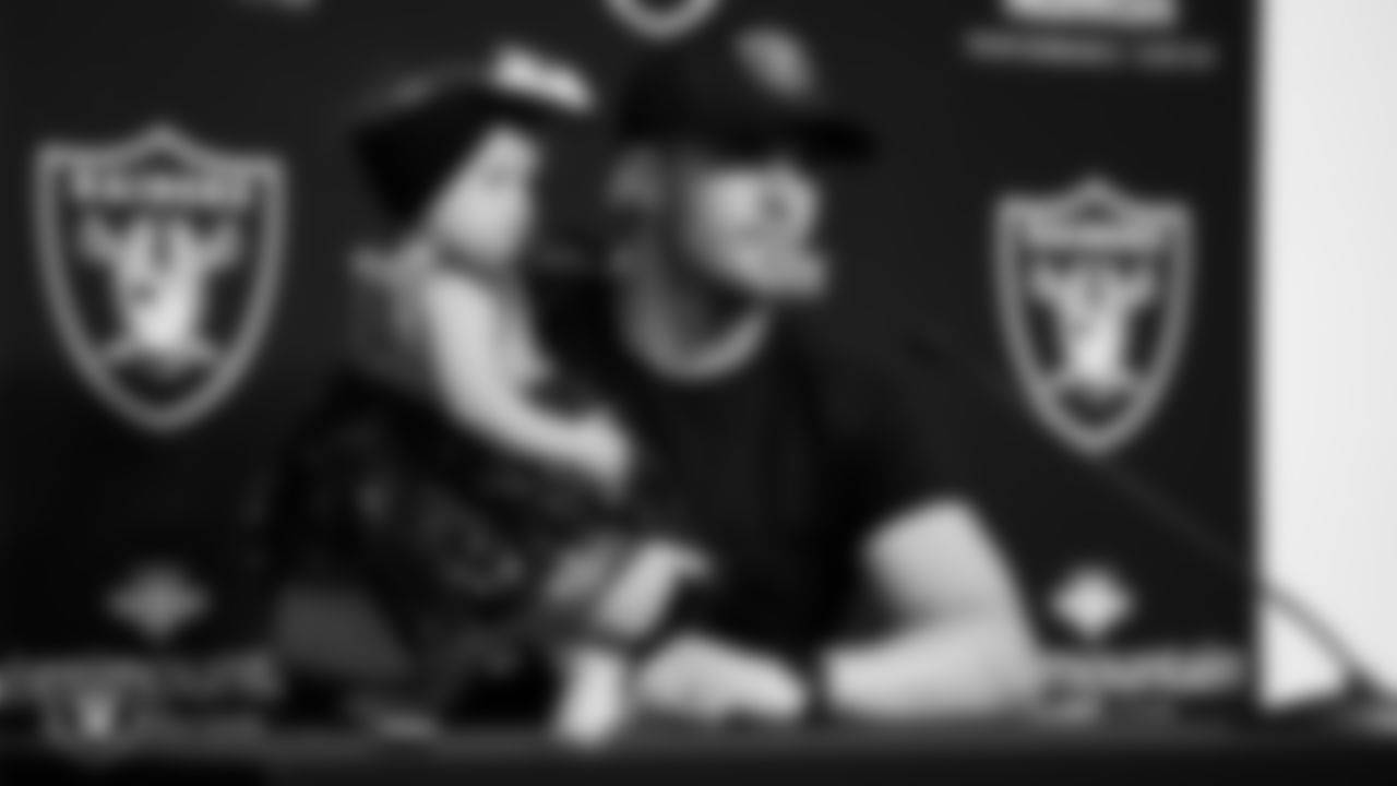 Las Vegas Raiders quarterback Derek Carr (4) with his daughter during a press conference after signing an extension.
