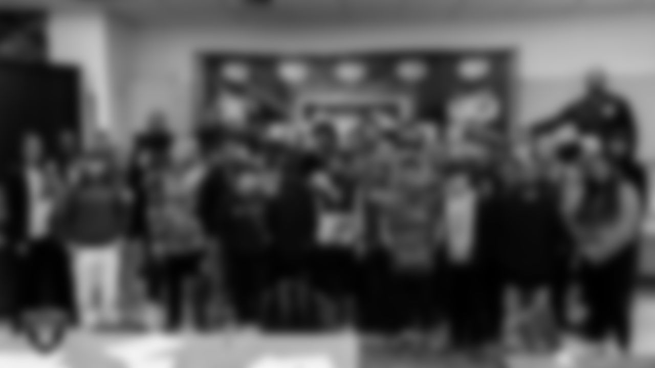 Las Vegas Raiders defensive tackle Matthew Butler (94) and cornerback Sam Webb (27) poses for a photo with students and teachers during the Hip Hop Entrepreneurship class.