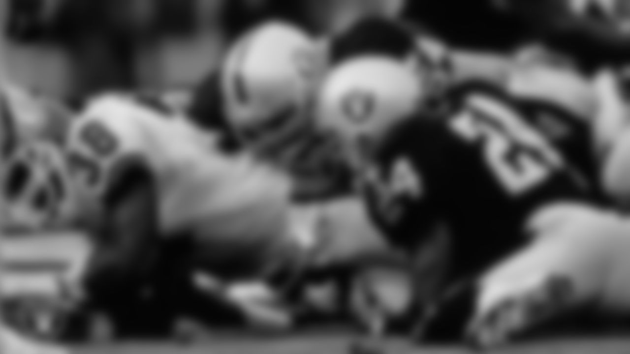 Raiders linebacker Greg Biekert (54) and defensive back Patrick Bates (24) make a tackle during the regular season home game against the Denver Broncos at Los Angeles Memorial Coliseum, Sunday, December 11, 1994, in Los Angeles, Calif.
