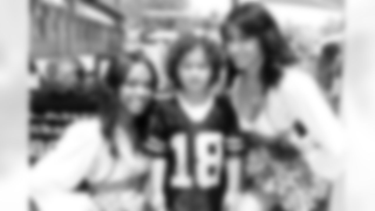 Raiderettes Tori and Lytisha pose for a photo with a young fan. Photo by Tony Gonzales.