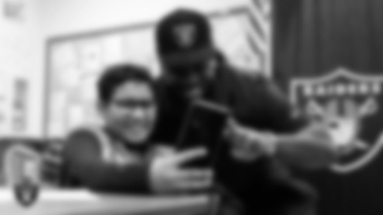 Las Vegas Raiders defensive tackle John Jenkins (95) takes a selfie with a member of the Hip Hop Entrepreneurship Program Academy at Grant Sawyer Middle School.
